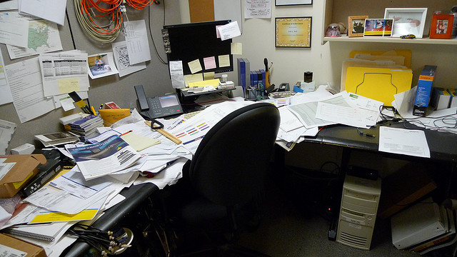Messy freelance writer's desk in a home office.
